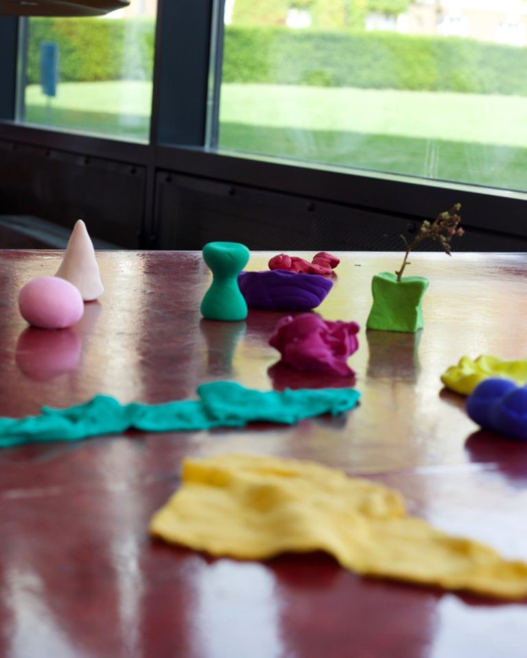 A variety of colourful playdough shapes arranged on a platform.